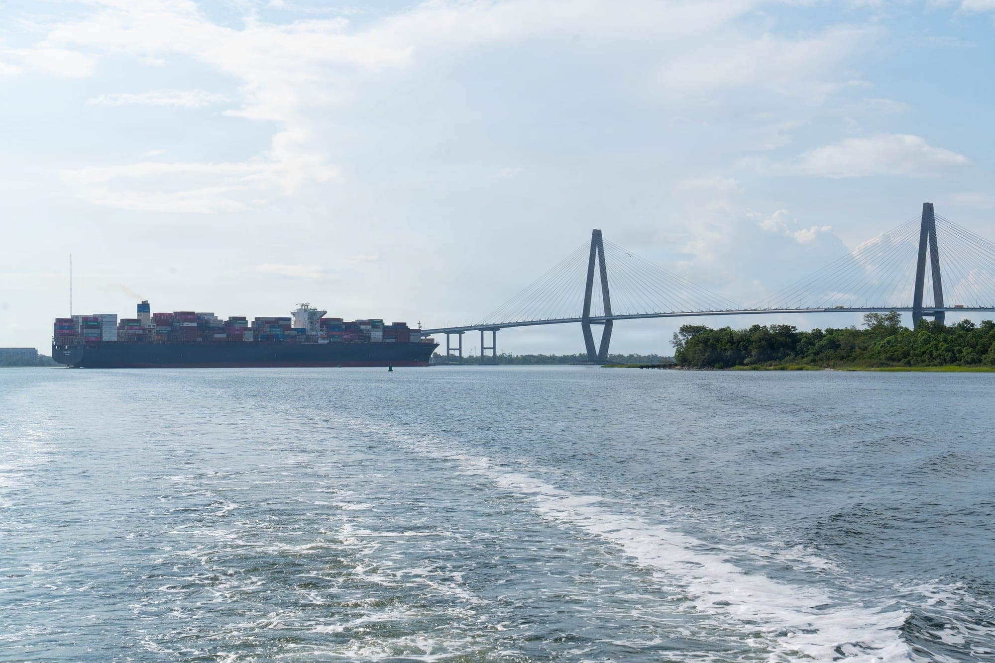 A container ship leaves the Port of Charleston and heads under the Arthur Ravenel Jr. Bridge, with Drum Island at right, on Aug. 27, 2026. The photo was taken from the Army Corps of Engineers survey vessel Evans.