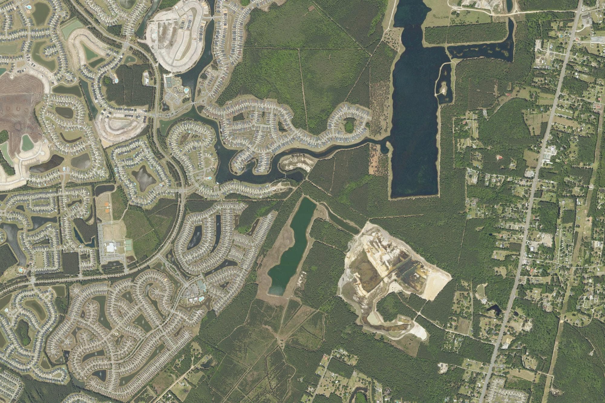 Woods and lakes lie between Cane Bay Plantation neighborhoods, left, and U.S. 17A, right, in Berkeley County in a U.S. Department of Agriculture aerial image from April 2023. Lake Village is planned for about 2,000 acres off U.S. 17A near Cane Bay.