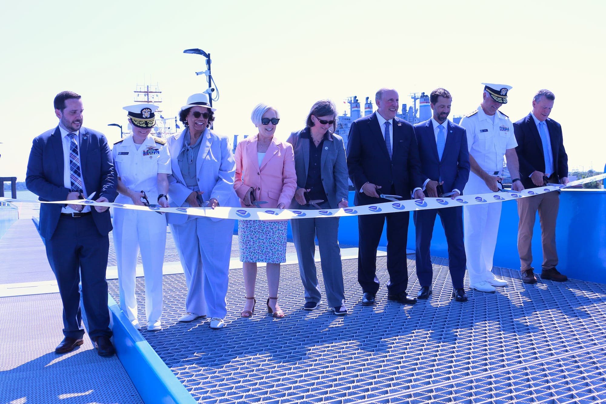 Commerce Deputy Secretary Paul Dabbar and NOAA Administrator Neil Jacobs, fourth and third from right, cut a ribbon with other officials and partners at NOAA's new pier in North Charleston on July 8, 2026.