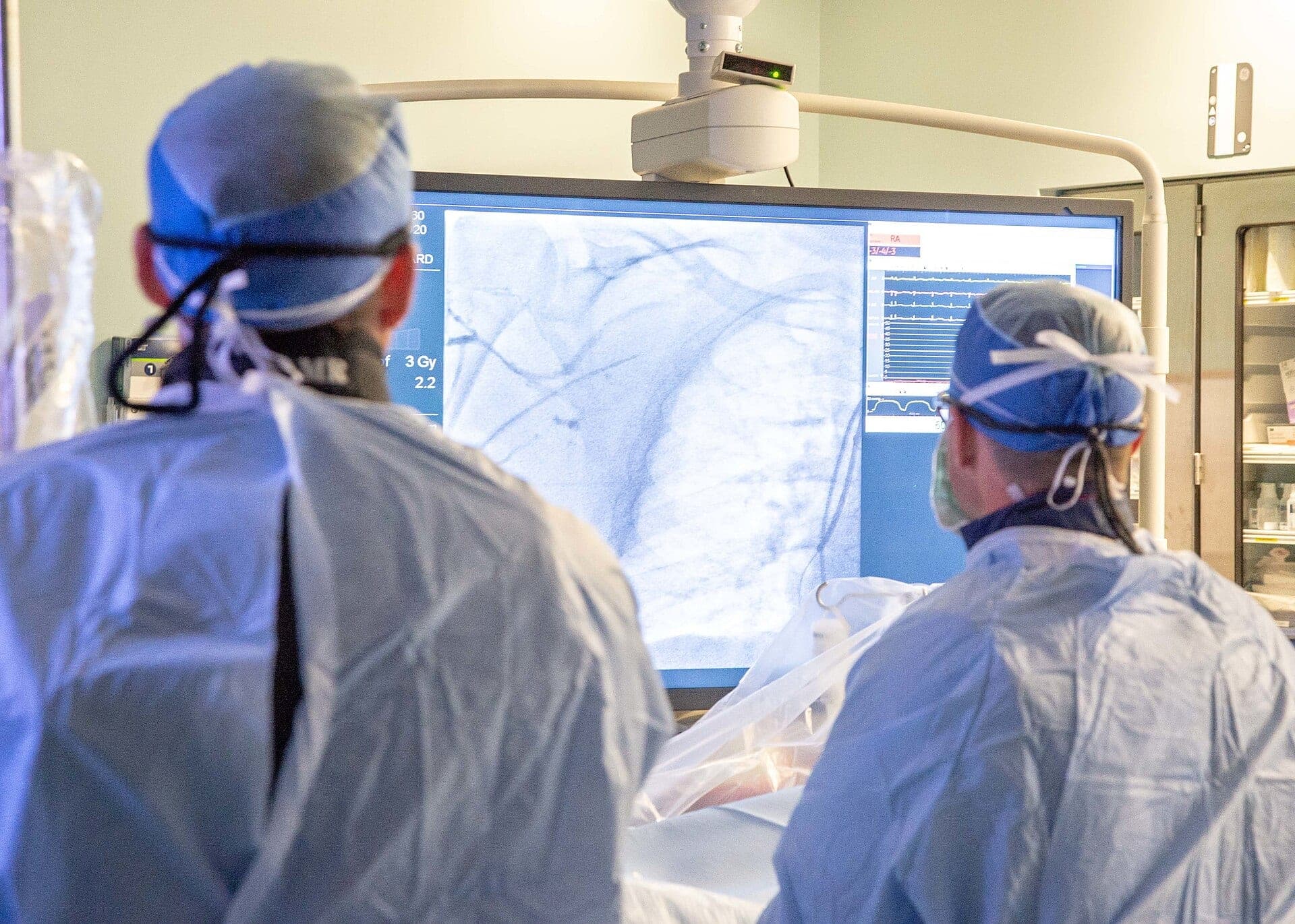 Cardiologists at Naval Medical Center San Diego watch an X-ray display during a cardiac catheterization in September 2020. The photo is a generic view of a cath lab and is not connected to Salus Scientific, which sells radiation protection for staff who work in procedure rooms like this one.